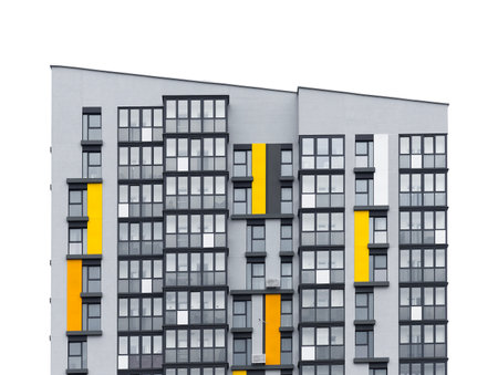Tall apartment building with geometric facade and multiple windows. Modern condominium structure representing urban housing, community living, and real estate property. Isolated on white background.の写真素材
