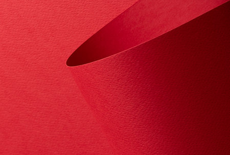 Elegant red designer paper sheet with smooth matte texture. Bright, festive backdrop with minimalistic design and sassy, happy color. Clean edges, perfect for cheerful, artistic projects.の写真素材