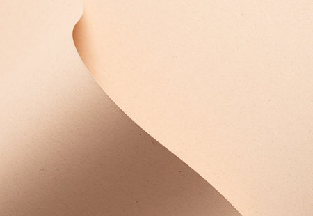 Beige designer paper texture with sandy, minimalistic backdrop. Premium, chic sheet with wave fold, matte finish, abstract, neutral tones. Contemporary, earthy, organic cardboard material in trendy,の写真素材