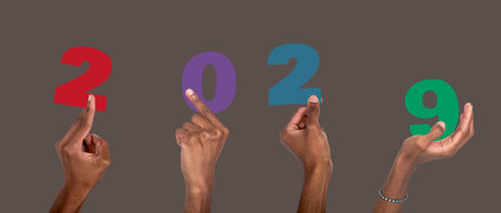 2029 new year festive concept. African American man hand raised and holding colorful number collage, joyful winter office celebration, christmas party and business team designの写真素材