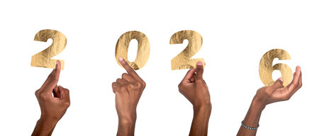 2026 New Year celebration. Black-skinned male hand holding golden metallic numbers with shiny textured foil, festive glowing concept of party and happiness. Isolated on white background.の写真素材