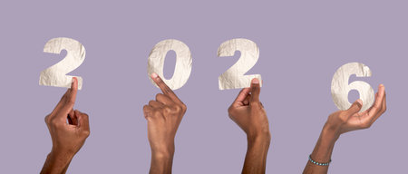 2026 New Year celebration. Male hand raised holding silver metallic numbers with textured foil, festive winter concept of joy, time and holiday party. Isolated on white background.の写真素材