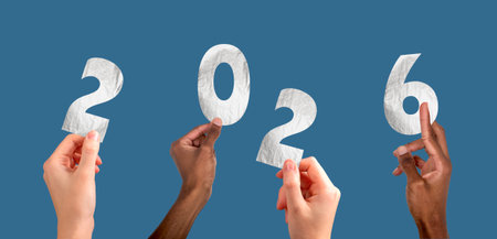 2026 new year celebration. Multiethnic team raising hands with metallic silver numbers, festive...