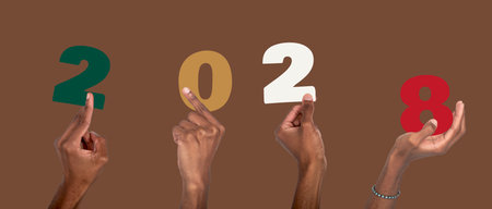 2028 new year concept of joyful celebration. African American man with dark skin raising hand and holding colorful number collage, festive office team spirit, christmas and business design background.の写真素材