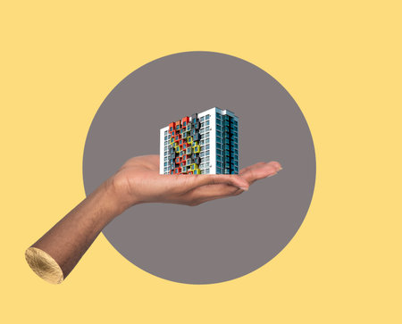 Building in hand investment concept. African male holding modern high rise apartment collage, showing real estate development, urban architecture, residential ownership and creative property promotionの写真素材