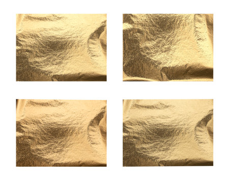 Golden foil texture background. Shiny metallic surface with polished reflective pattern and elegant shimmer, luxurious decorative material for festive, modern, and creative design, isolated on whiteの写真素材