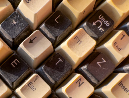 Close-up view of old computer keyboard keys with visible wear, dust, and faded symbols. Vintage...