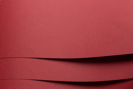 Red layered paper background with multiple folds. Matte textured surface and rich warm color....