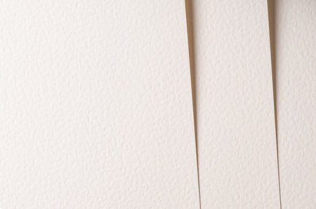 Beige paper sheets arranged vertically with central gap. Textured surface creates layered structure....
