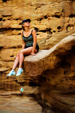 beautiful girl sitting on a rock in Red Canyonの写真素材