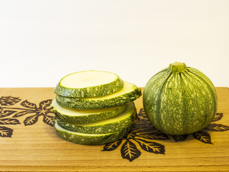 Photography round green zucchini chopped on wooden board .の写真素材