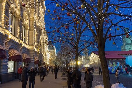 Moscow , Russia - February 21, 2015 : Illuminated GUM and Christmas market in holiday decoration on the Red Square . People walk on the Red Square and the sidewalk . Moscow, Russia.のeditorial素材