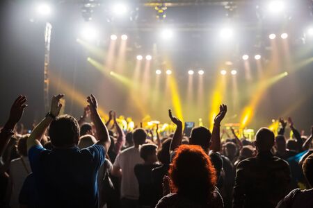 Crowd at concert and blurred stage lights . Close up of photographing with smartphone during a...