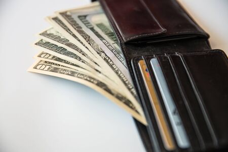 Currency in the wallet and on the table. Calculator and pen.