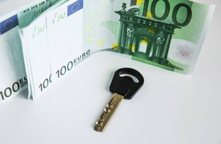 Currency and house keys on the table.の写真素材