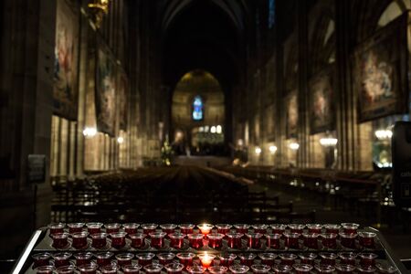 Lighting candles in a catholic temple . Candles are lit near the altar in a Catholic temple.の写真素材