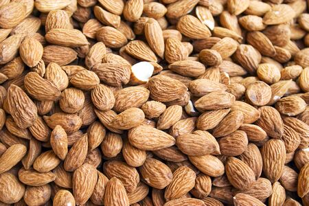 a lot of almonds with one opened almondの写真素材