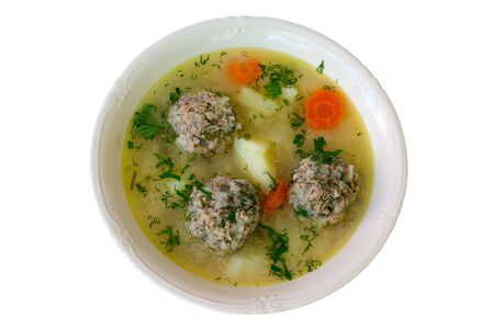 soup with meatballs,potatoes and carrot in plate isolated on white backgroundの写真素材