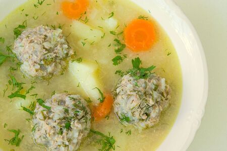 soup with meatballs, potatoes,carrot,parsley and dill in white plateの写真素材