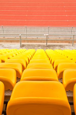 Rows of yellow seats in stadiumの写真素材