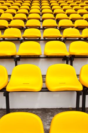 Row of yellow seats in stadiumの写真素材