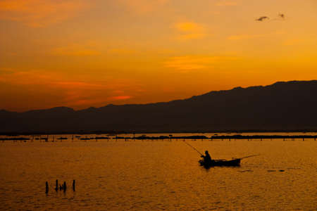 Fisherman in Payao lake, north of Thailandの写真素材