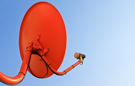 Red satellite dish in bright color skyの写真素材