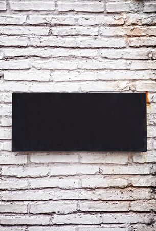 Old metal plate on white brick wallの写真素材