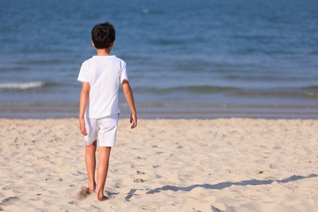 Young boy in white cloth on beachの写真素材