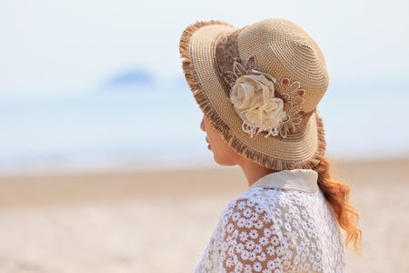 Woman in luxury hat looking to the seaの写真素材