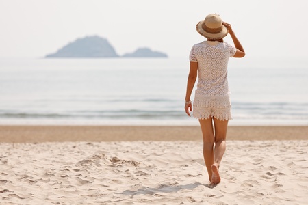 Woman walking on tropical beachの写真素材