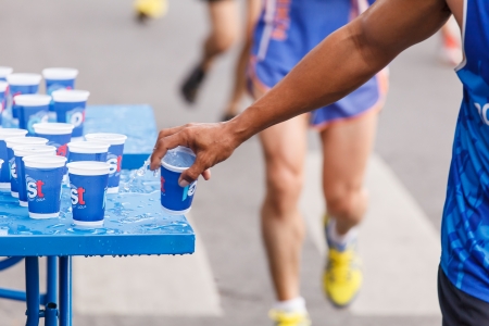 BANGKOK, THAILAND - NOVEMBER 17 : Unidentified runner catching up water during Standard Charterd Bangkok Marathon 2013 running championship on November 17, 2013 in Bangkok, Thailand.のeditorial素材