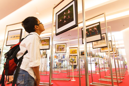 BANGKOK-JAN 05: Unidentified Thai boy looking at photos in â€˜Magical Kenya by Mr.David...