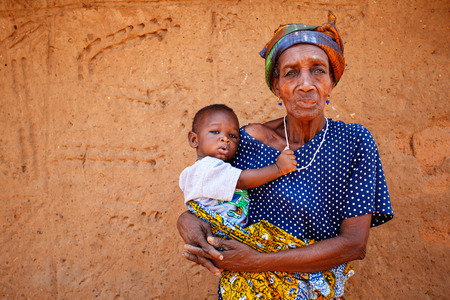 Old Ghanaian woman holding boy in armsのeditorial素材