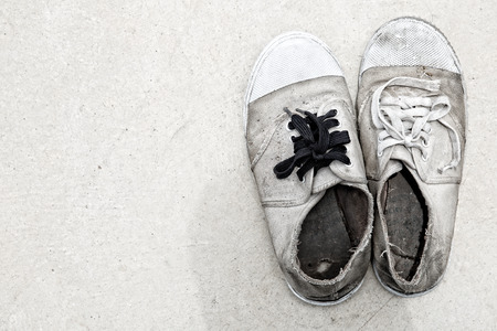 Dirty old shoes on concrete floor process in grunge styleの写真素材
