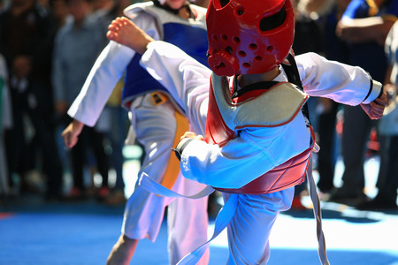 Kids fighting on stage during Taekwondo tournamentの写真素材