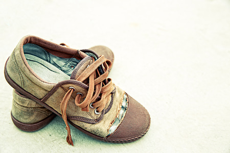 Old shoes on dirty background processed in grunge styleの写真素材