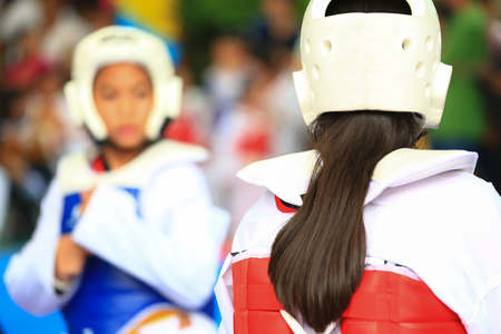 Girls fighting on stage during Taekwondo tournamentの写真素材