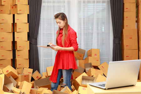 Asain woman in red dress work at home, online shopping businessの写真素材