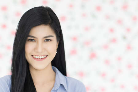 Cute and beautiful young black long hair Asian woman standing and smiling look at the camera with a self-confident and friendly pose.の写真素材