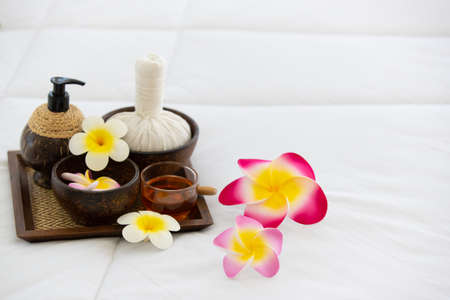 Set of spa treatments, natural oil, and plumeria flowers.