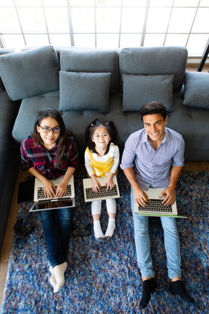 Three members of diverse family, Caucasian father and Asian mother and little half daughter sitting...