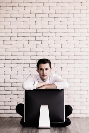 Businessman sitting with hopeless on old and obsoleted model retro style computer. Idea for the employee in old-fashioned and outdated technology no job, get fired and sad in office. Black and white.の写真素材