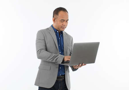A self-confident middle age senior Asian man in a blue business casual shirt with a grey jacket...