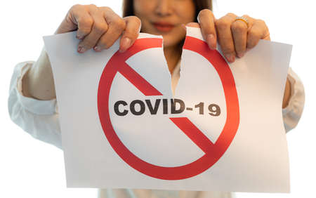 Woman holding and tearing paper with Covid-19 coronavirus warning words. The idea or concept for the ending, happiness and free after finishing and recovered from Coronarivus, on white background.の写真素材