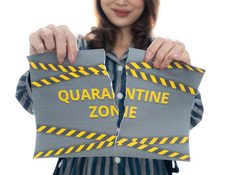 Woman shows and tearing paper with Covid-19 lockdown quarantine zone words. The idea or concept for the ending, happiness and free after finishing and recovered from Coronarivus.の写真素材