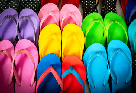 Rows of bright colorful rubber slippers that popular in sand beach and holiday, summer travel. Easy simple shoes for use in the casual day. Process in vintage film style.の写真素材