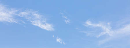 Blue clear sky with white clouds and copyspace, crop as banner ratioの写真素材