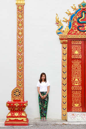 Asian woman in southern native Thai style pattern paint pants in with traditional Thailand Buddhist temple architecture.の写真素材