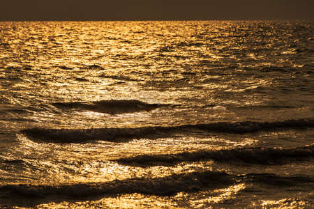 Texture of tropical sea water and wave in golden light of sunset.の写真素材